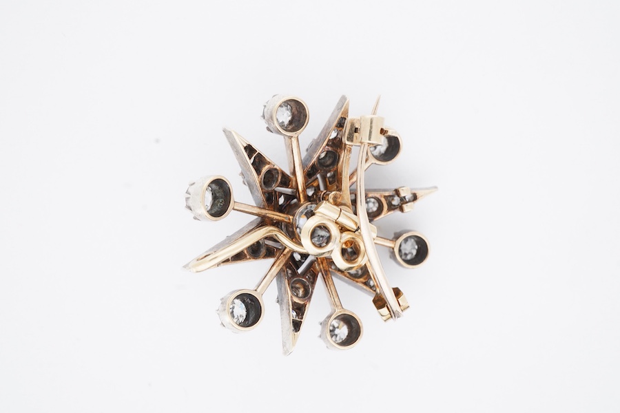 A Victorian diamond brooch/pendant, late 19th century, designed as a star, set with circular-cut, cushion-shaped and rose-cut diamonds totalling approximately 1.80 carats, mounted in silver and gold, length 3cm, gross we